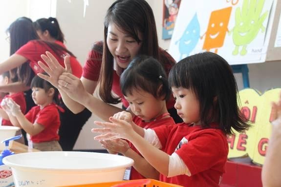 Các cô giáo hướng dẫn học sinh rửa tay đúng cách.